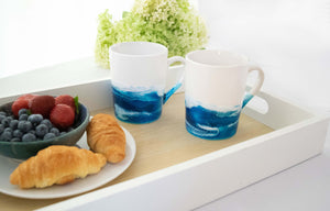 two blue and white ocean mugs on tray with breakfast foods